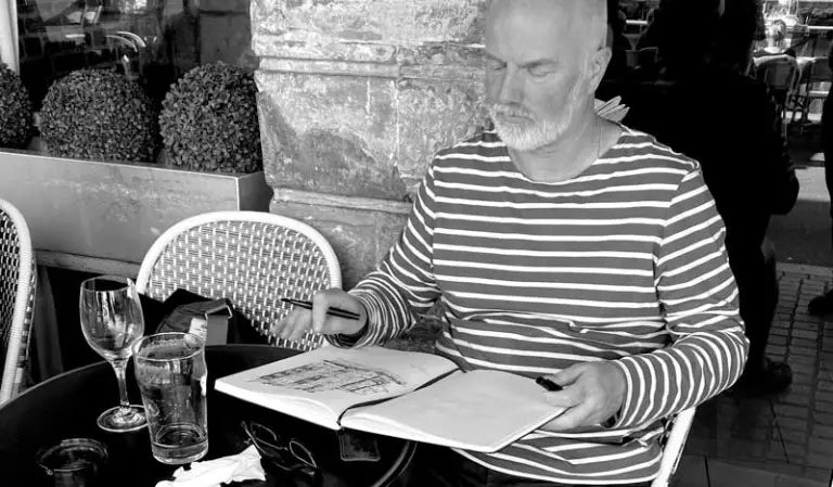 Artist Sean Briggs sketching in a cafe